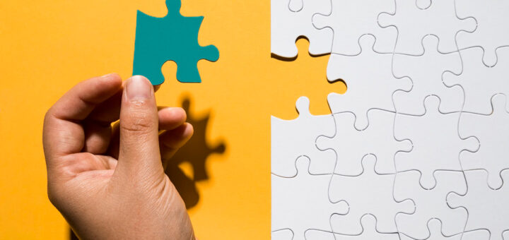 mão de homem montando quebra cabeça