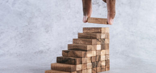 mão de homem negro incluindo o último degrau de uma escada de peças de madeira