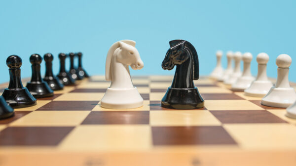 Jogo de xadrez destacando duas peças de cavalo como se fosse o PO x PM