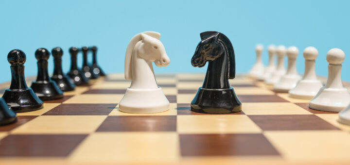 Jogo de xadrez destacando duas peças de cavalo como se fosse o PO x PM